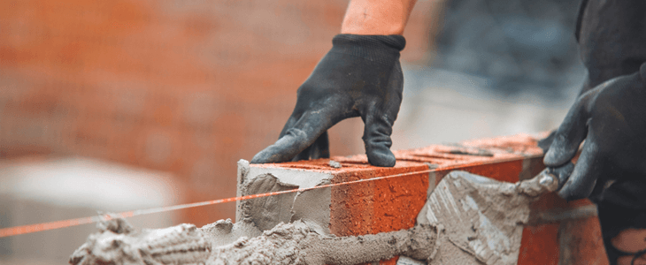 a close up view of a person laying bricks