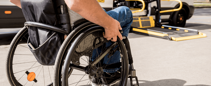 a person in a wheelchair prepares to board a bus