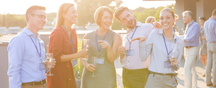 a group of young professionals stand and smile together