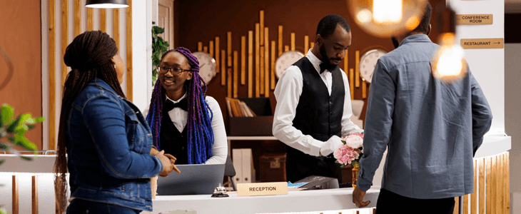 a woman and a man check into a hotel
