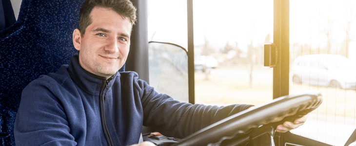 a charter bus driver smiles at the camera