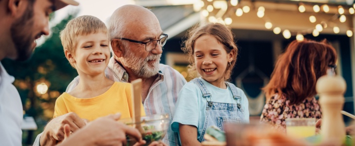 Two grandchildren sit with their grandfather