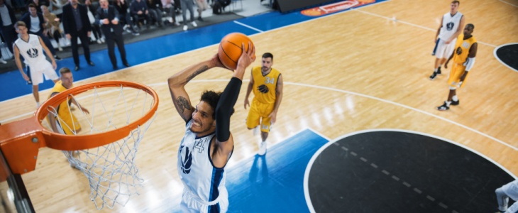 A basketball player scores a slam dunk during a game