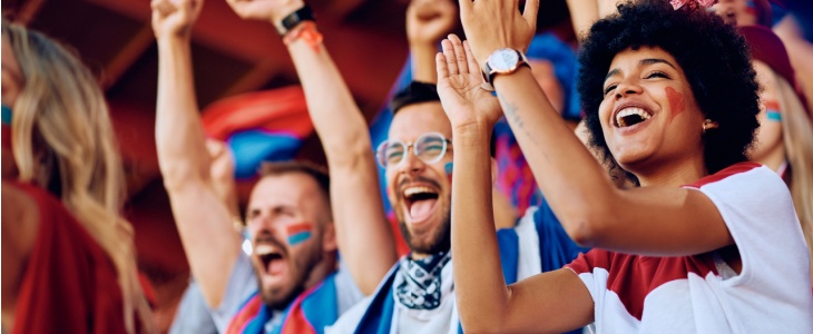 Sports fans cheer on their team during a game