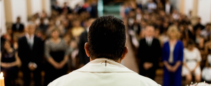 A priest stands at the pulpet