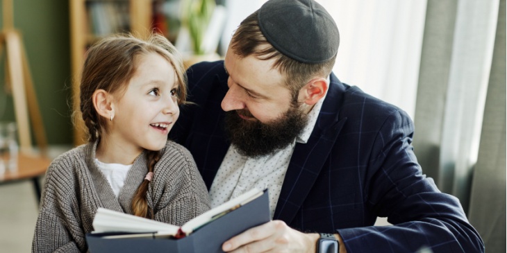 A girl and her father read a book together