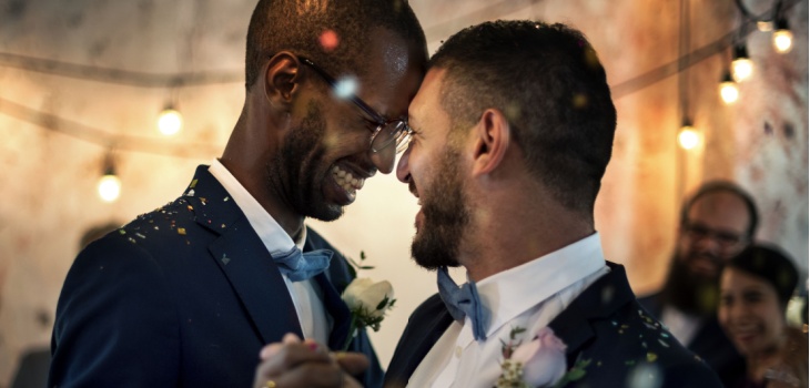 Two grooms share a dance at their wedding